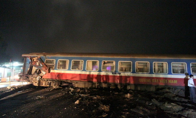 Toàn bộ toa tàu bị đứt rời nằm chắn ngang đường Quốc lộ 1 trong tai nạn tối ngày 10-3 - Ảnh: Quốc Nam