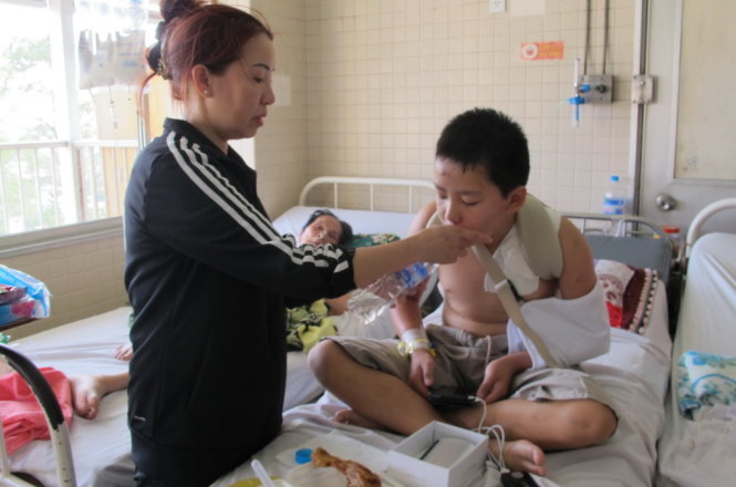 Mẹ bé Pranyn Tran chăm sóc con bên giường bệnh - Ảnh: Thùy Dương