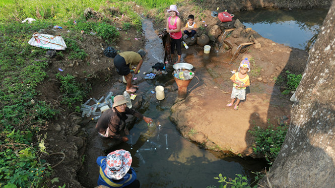 Người dân ở buôn Kbu, xã Hòa Khánh, TP Buôn Ma Thuột (Đắk Lắk) lấy nước sinh hoạt tại nguồn nước ngầm - Ảnh: Tiến Thành