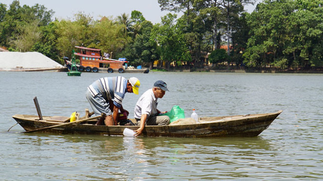 Nhà nghiên cứu Phạm Văn Miên lấy mẫu nước trên sông Đồng Nai để xem xét chất lượng sau khi có dự án lấn sông - Ảnh: S.Định