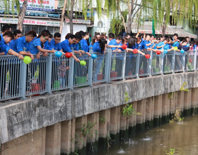 Các bạn trẻ thành phố thả cá xuống kênh Nhiêu Lộc - Thị Nghè và vận động người dân không câu cá  Ảnh: Q.L