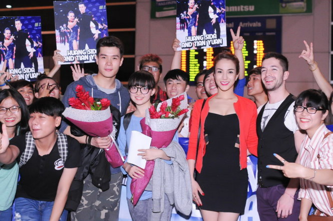 Thí sinh Diệp Lâm Anh và bạn nhảy (phải) đón cặp vận động viên dancesport người Trung Quốc Huang Sida và Tian Yuan (trái) tại sân bay - Ảnh CTS