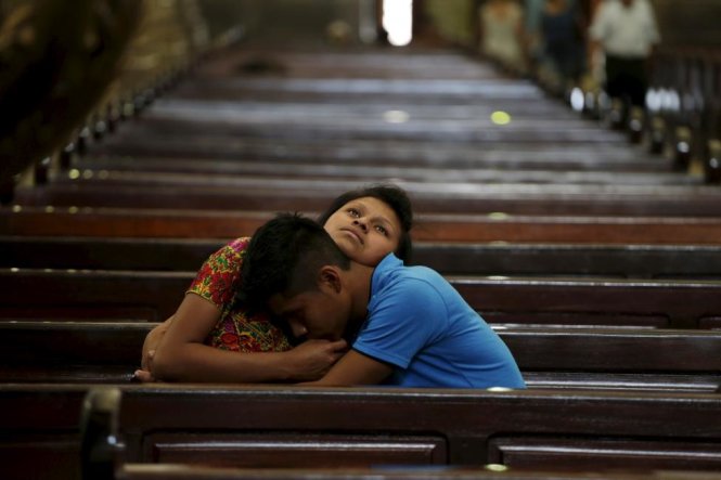 Một cặp đôi ôm nhau trong khi đang ngồi trong một nhà thờ ở thành phố Guatemala, ngày 1/4/2015 - Ảnh: Jorge Dan Lopez