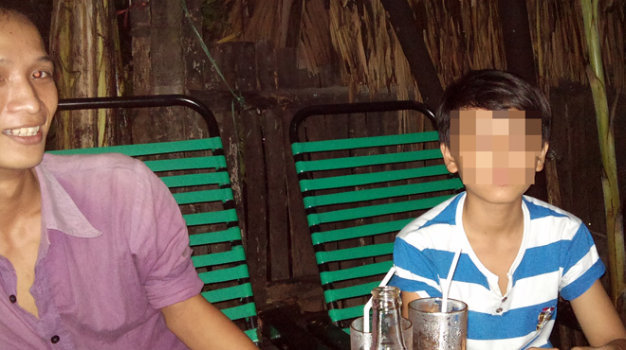 Thuận (trái) - một kẻ phạm tội tình dục với trẻ em trai - rao giá “đi khách” của bé trai ngồi bên cạnh là 2 triệu đồng vào chiều 8-10 tại một quán cà phê trên hương lộ 80B (P.Hiệp Thành, Q.12, TP.HCM) - Ảnh: N.Khải