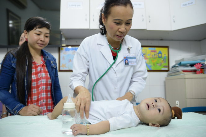 Bác sĩ đang kiểm tra sức khỏe cho bé Huy - Ảnh: Hữu Khoa