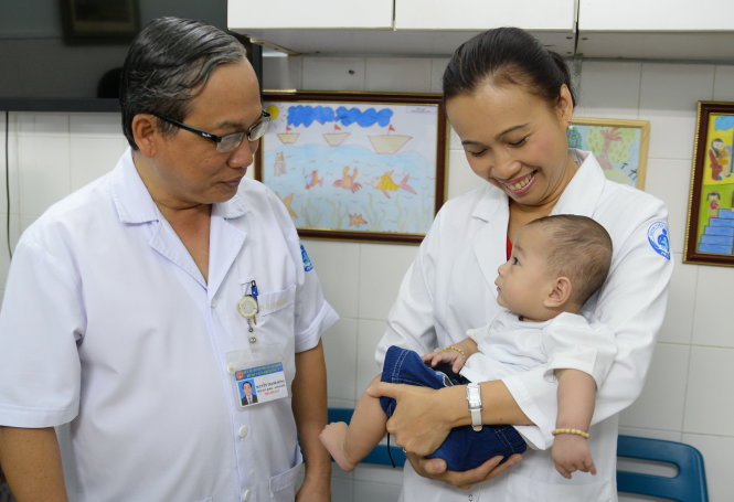 Ông Nguyễn Thanh Hùng - Giám đốc bệnh viện Nhi Đồng 1 thăm hỏi sức khỏe bé Huy - Ảnh: Hữu Khoa