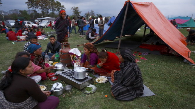 Nhiều người dân Nepal đang phải ăn, ngủ ngoài trời vì sợ những cơn dư chấn còn tiếp tục - Ảnh: Reuters