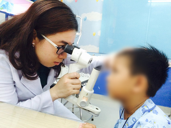 Bác sĩ khám kiểm tra mắt bị chấn thương cho một bệnh nhi tại Bệnh viện Mắt TP.HCM - Ảnh: L.TH.H.