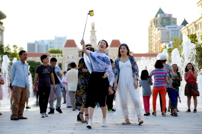 Du khách người Nhật vui vẻ chụp ảnh lưu niệm trên phố đi bộ Nguyễn Huệ - Ảnh: Hữu Khoa