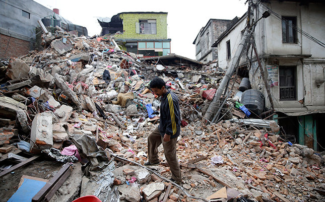 Một người đàn ông trên đống đổ nát sau thảm họa động đất ở Nepal - Ảnh: EPA