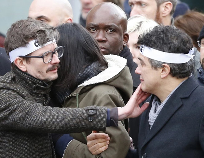 Họa sĩ biếm Renald Luzier (trái) và cây bút viết xã luận Patrick Pelloux của Charlie Hebdo (phải) trong cuộc diễu hành phản đối sau vụ tấn công khủng bố tại Paris ngày 11-1 - Ảnh: AP 