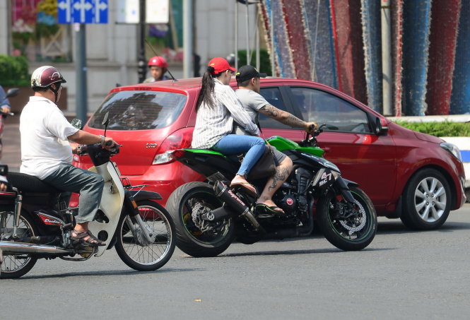 Một thanh niên chở theo một phụ nữ chạy xe môtô phân khối lớn không đội mũ bảo hiểm chạy trên đường Lê Duẩn, Q.1, TP.HCM  - Ảnh: Tiến Long