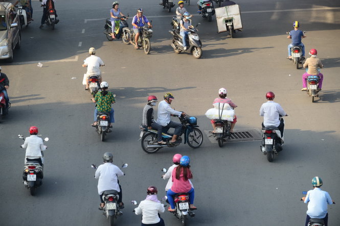 Một chiếc xe máy vượt đèn đỏ cố gắng vượt qua dòng xe đang chạy đúng chiều trên đường Hồng Bàng, TP.HCM - Ảnh: Tiến Long