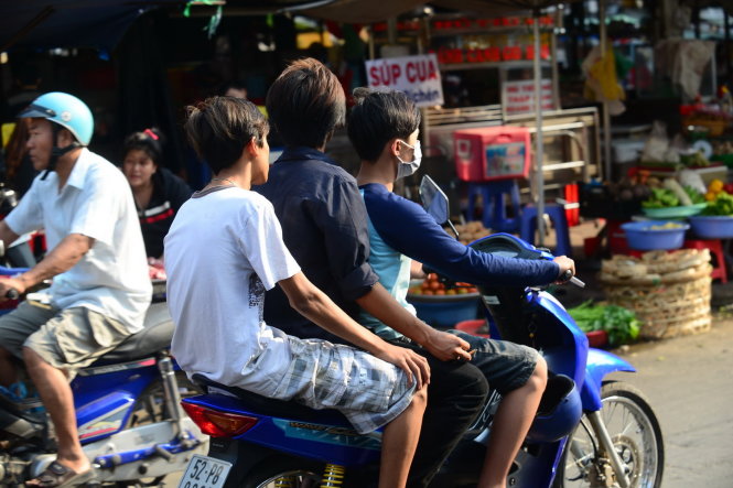 Ba thanh niên chạy xe máy không đội nón bảo hiểm chở 3 trên đường Vũ Tùng, Q. Bình Thạnh, TP.HCM  - Ảnh: Tiến Long