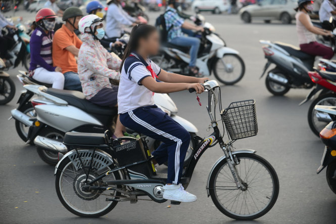 Một học sinh đi xe đạp điện không đội nón bảo hiểm trên đường Nguyễn Kiệm, Q. Gò Vấp, TP.HCM - Ảnh: Tiến Long