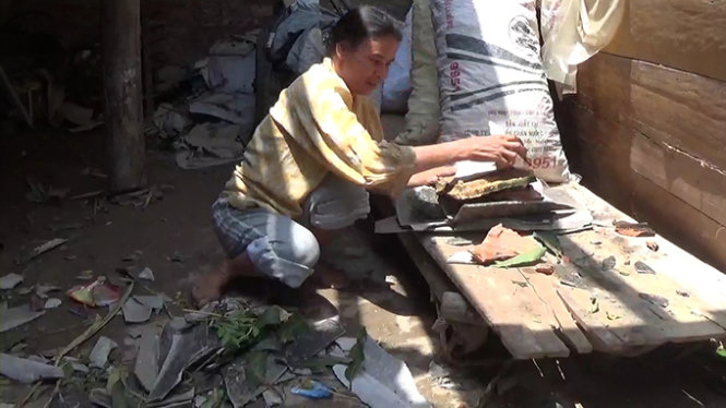 Bà Vân Thị Hợp dọn dẹp lại đống đổ nát sau trận lốc xoáy chiều 4-5 - Ảnh: Doãn Hoà 