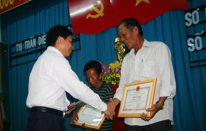 Ông Lương Phan Sảng – phó giám đốc Vietcombank chi nhánh Khánh Hòa (trái) trao thưởng cho ông Nguyễn Văn Thời (phải) và ông Nguyễn Quốc Bảo. Ảnh:Phan Sông Ngân