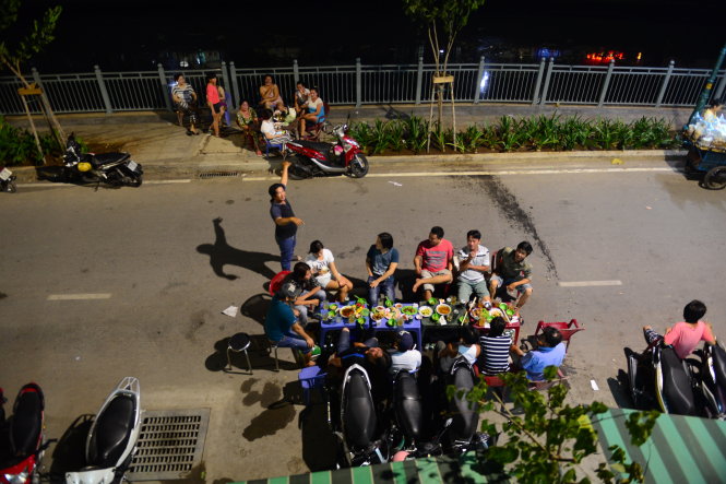 Bày bàn ra nhậu dưới lòng đường, bên cạnh là một nhóm phụ nữ ngồi chiếm hết vỉa hè kênh Tân Hóa - Lò Gốm - - Ảnh: Quang Định