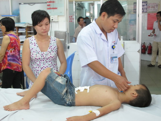 Bác sĩ khám cho bé Lê Xuân Hiếu sau khi được phẫu thuật tại Bệnh viện Nhi Đồng 1 - Ảnh: T.Dương