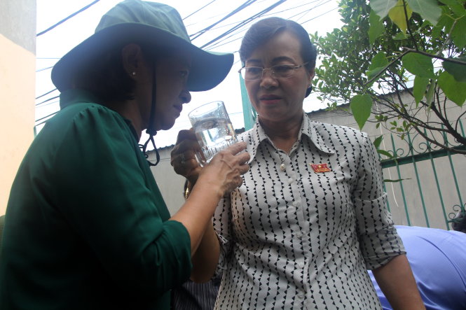 chủ tịch HĐND TP Nguyễn Thị Quyết Tâm (bên phải) và trưởng ban tuyên giáo Thành ủy TP Thân Thị Thư kiểm tra chất lượng nước tại một hộ dân trên đường Tỉnh lộ 43. Ảnh Q.Khải