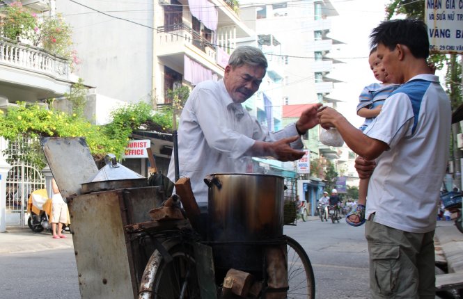 Ông Hồ Ngần đạp xe bán bánh bao trên đường phố Huế - Ảnh: P.T.