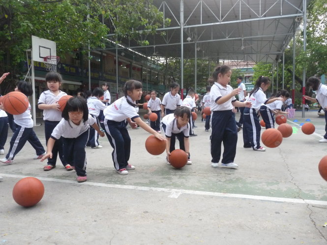 Học sinh lớp 1 Trường tiểu học Lương Thế Vinh học chơi bóng rổ trong tiết thể dục  Ảnh: XUÂN BÌNH