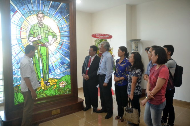 Ông Bùi Chí Công (trái) trao tặng bức tranh kính về Bác Hồ mang tên “Nhiệm vụ tối cao” cho Trường ĐH Khoa học xã hội nhân văn -Ảnh: QUANG PHƯƠNG