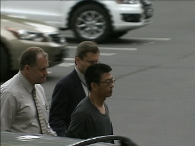 Hoàng Hỉ Văn (phải), một người Trung Quốc, bị áp giải hôm 1-5 với cáo buộc đánh cắp bí mật thương mại của công ty năng lượng của Mỹ ở Charlotte, North Carolina - Ảnh: Reuters