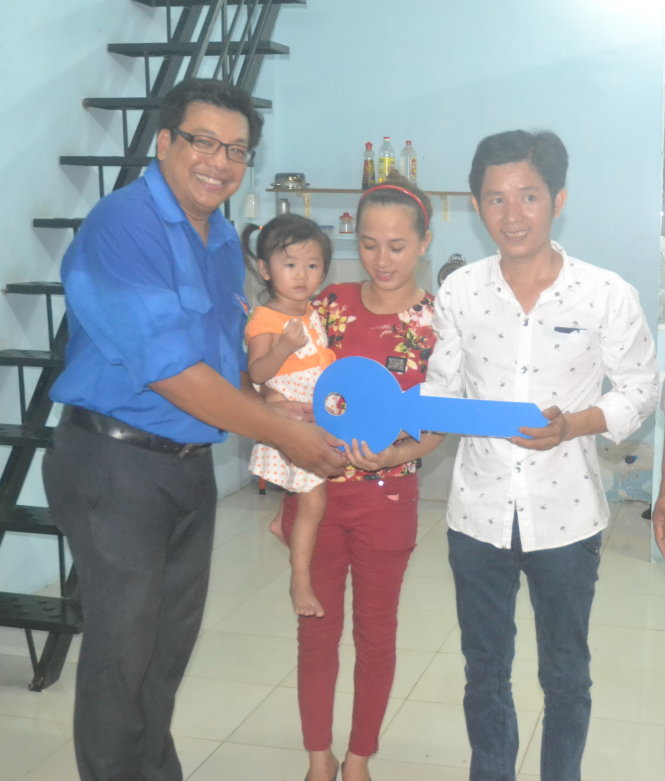 Gia đình công nhân Thân Văn Tư nhận chìa khóa tượng trưng của  “căn phòng mơ ước” - Ảnh: Q.Phương