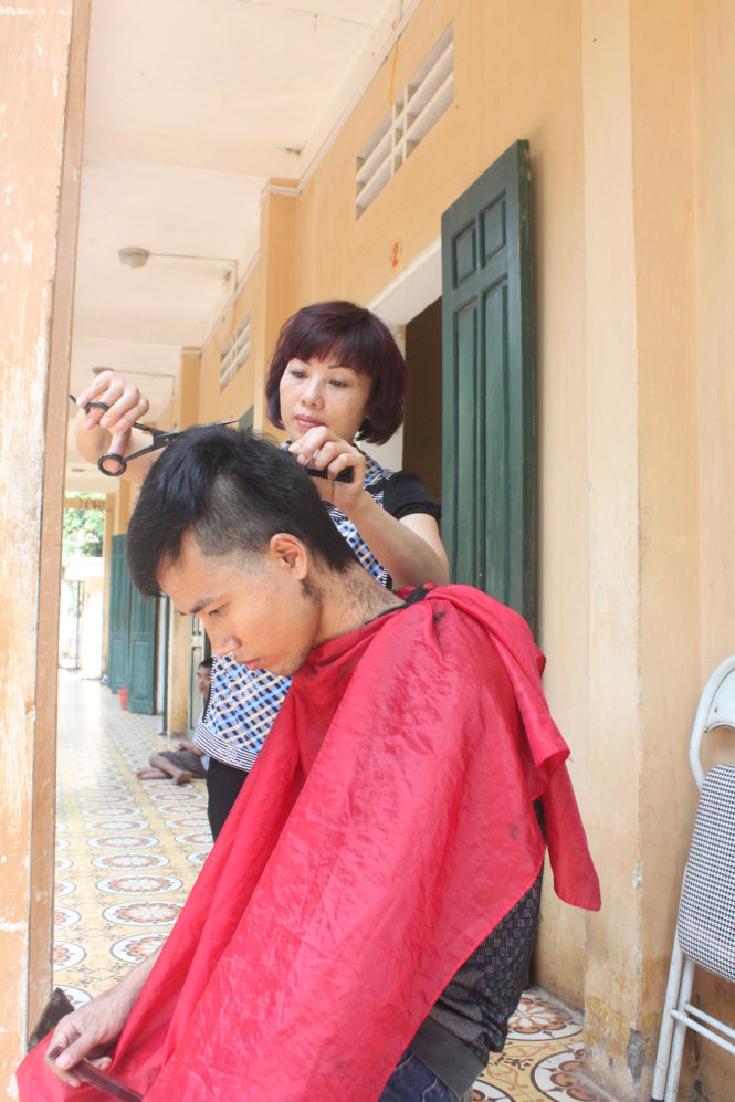Chị Hoa cắt tóc cho Minh trong những lần lên thăm tại Trung tâm Bảo trợ xã hội số 4 - Ảnh: T.Lụa