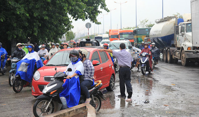 Nhân viên trung tâm đăng kiểm phải ra điều tiết giao thông trên xa lộ Hà Nội - Ảnh: Mậu Trường