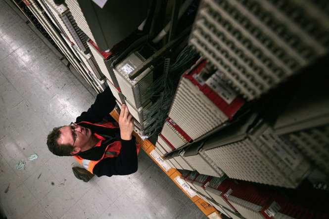Một nhân viên nhà mạng Telstra kiểm tra hệ thống xử lý viễn thông và băng rộng tại một trung tâm ở Melbourne, Úc - Ảnh: Bloomberg