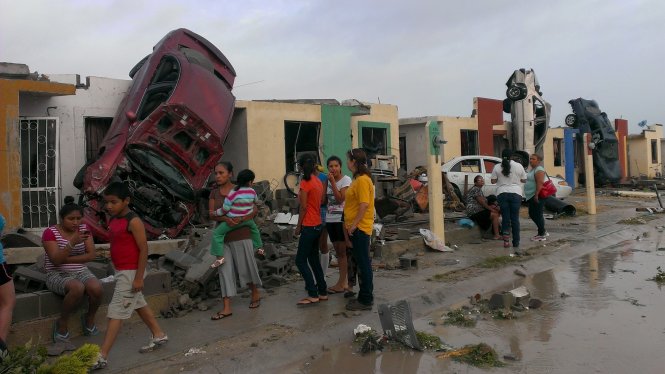 Lốc xoáy khiến cuốn một chiếc xe lên mái nhà của người dân thành phố Ciudad Acuna - Ảnh: Reuters
