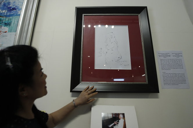 Họa sĩ Văn Dương Thành bên bức ký họa Đại tướng Võ Nguyên Giáp vẽ tặng bà vào năm 1999. Triển lãm đang diễn ra tại Bào tàng Lịch sử quân sự Việt Nam - Ảnh: Nguyễn Khánh