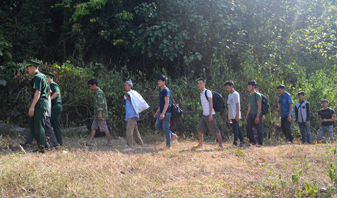 Cơ quan chức năng dẫn giải nhóm người vượt biên trái phép qua biên giới Việt - Lào - Ảnh: Minh Toàn
