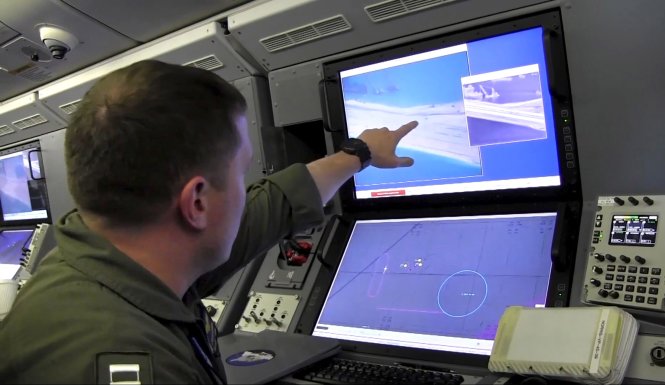 Binh sĩ hải quân Mỹ trên máy bay do thám P-8A Poseidon chỉ rõ hành động cải tạo đảo rầm rộ của Trung Quốc trong chuyến bay có mặt nhà báo CNN Jim Sciutto - Ảnh: Reuters