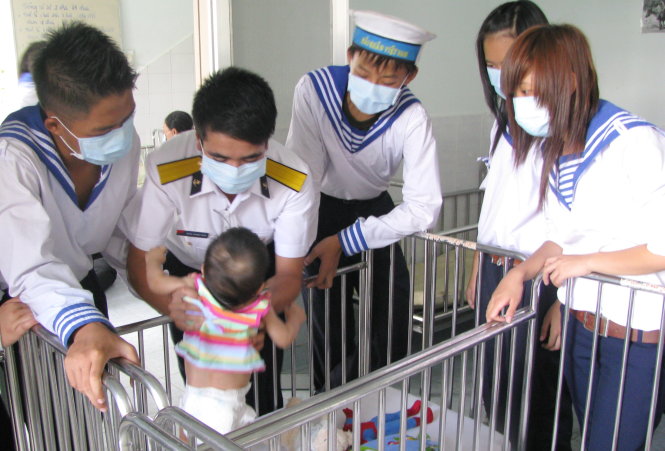 Học viên khóa “Học kỳ trong quân đội” của Nhà văn hóa Thanh niên TP.HCM đến thăm, tặng quà cho các em nhỏ tại một trung tâm nuôi dạy trẻ khuyết tật - Ảnh: Q.L.