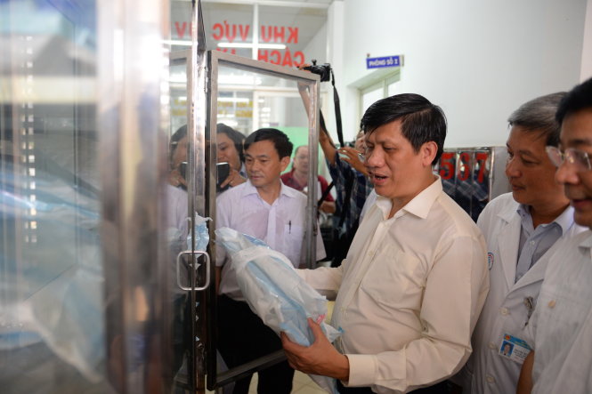 GS.TS Nguyễn Thanh Long - Thứ trưởng Bộ Y tế kiểm tra các dụng cụ bảo hộ cho y bác sĩ khi tiếp xúc với bệnh nhân MERS- CoV - Ảnh: Hữu Khoa