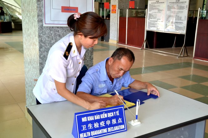 Hướng dẫn du khách Trung Quốc khai báo y tế trước khi nhập cảnh vào Việt Nam, tại Cửa khẩu quốc tế Lào Cai - Ảnh: Hồng Thảo