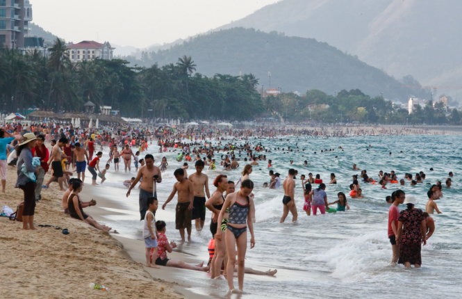 Người dân và du khách đổ ra bãi biển Nha Trang tắm biển, nghỉ ngơi - Ảnh: Tiến Thành