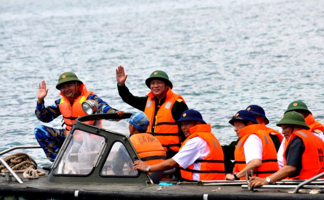 Thứ trưởng Trương Minh Tuấn đứng trên xuồng CQ chào tạm biệt CBCS trên đảo trước khi trở lại tàu 571