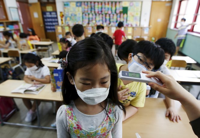 Học sinh tiểu học ở Seoul được kiểm tra thân nhiệt ngay tại lớp ngày 9-6 - Ảnh: Reuters