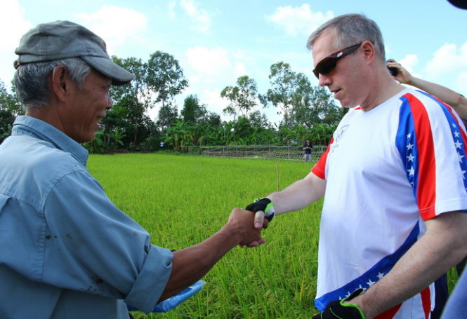 Đại sứ Hoa Kỳ Ted Osius trao đổi về công việc sản xuất với nông dân Lê Văn Hùng Anh (khu vực Bình Phó B, phường Long Tuyền, quận Bình Thủy) sáng 10 – 6. Ảnh: Chí Quốc