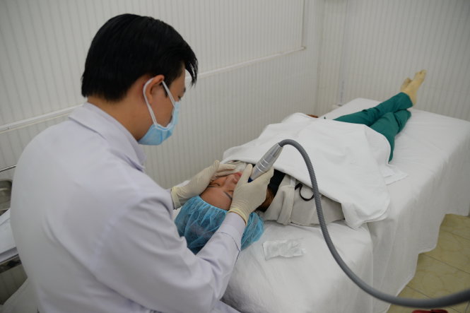 Bác sĩ Bệnh viện Da liễu TP.HCM lăn kim bằng máy để giúp trẻ hóa da - Ảnh: Hữu Khoa
