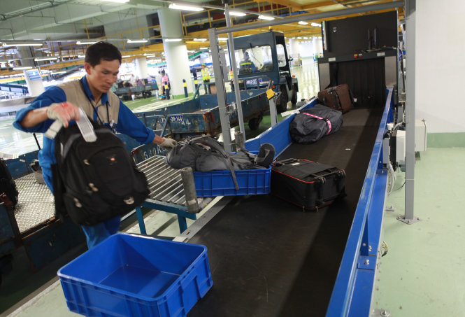 Hành lý ký gửi từ máy bay đến được đưa vào băng chuyền ra đảo hành lý tại cảng hàng không Nội Bài - Ảnh: Tuấn Phùng