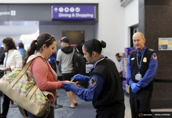Các nhân viên TSA kiểm tra một hành khách ở sân bay San Francisco, California - Ảnh: Reuters