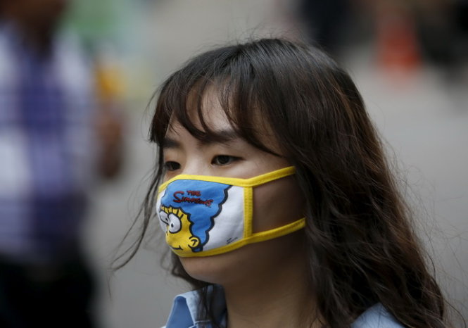 Dịch cúm MERS bùng phát ở Hàn Quốc. Trong ảnh, một phụ nữ đeo khẩu trang để phòng ngừa MERS khi đang đi bộ ở khu mua sắm Myeongdong, Seoul ngày 11-6. Ảnh: Reuters