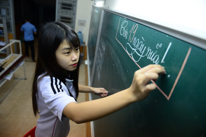Một học sinh nữ sau khi kết thúc ngày ôn thi đã ghi lên bảng số ngày còn lại để đếm ngược tới kỳ thi (ảnh chụp tối 10-6 tại Trường THPT Trí Đức, Q.Tân Phú, TP.HCM)