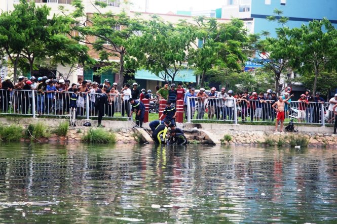 Lực lượng chức năng đang đưa thi thể nam thanh niên lên bờ - Ảnh: Hải Hiếu