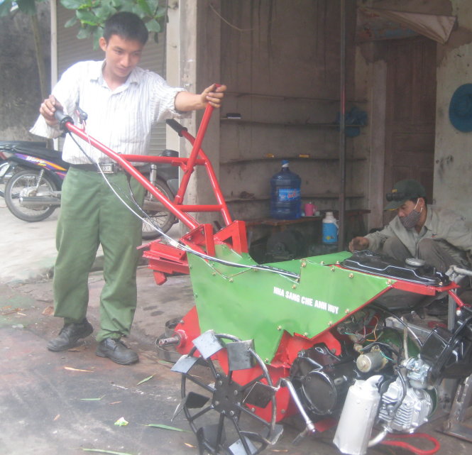 Tạ Đình Huy (trái) cùng chiếc máy nông nghiệp đa năng - Ảnh: Duy Ngợii